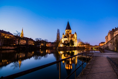 illuminated-buildings-by-river-against-sky-dusk.jpg